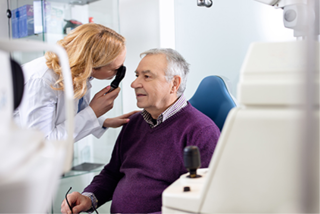 איש מבוגר עובר בדיקת ראייה ע"י רופאת עיניים